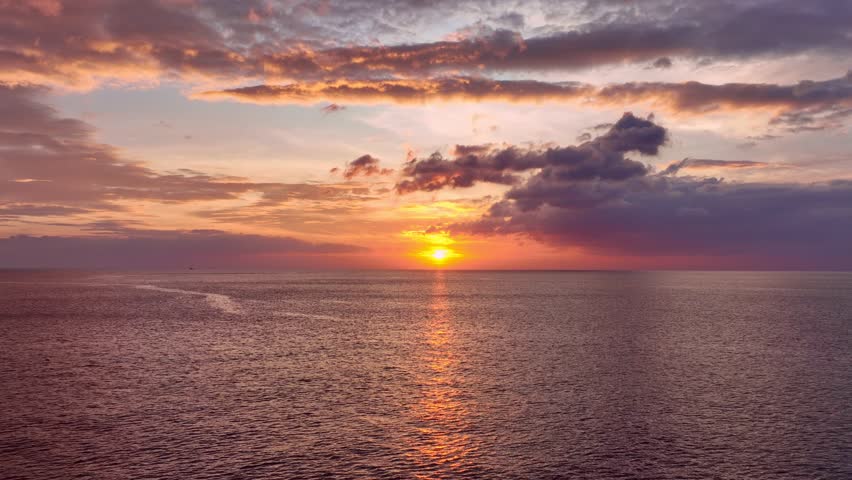 Colorful sunset or sunrise above the sea surface,Aerial view drone fly over open sea,Reflected sun beautiful light of nature on water surface,Sunset over ocean,Sea summer and travel vacation concept | Shutterstock HD Video #1098514263