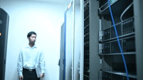 Computer engineer is setting up network in server room,Systems Maintenance Technician