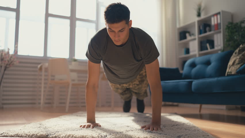 Young military man doing push ups at home, improving endurance, training time Royalty-Free Stock Footage #1098523449