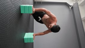 Athletic Muscular Man Doing Push-ups in the Gym. Concept of a Healthy Lifestyle and Workout. Slow Motion. Vertical Video.