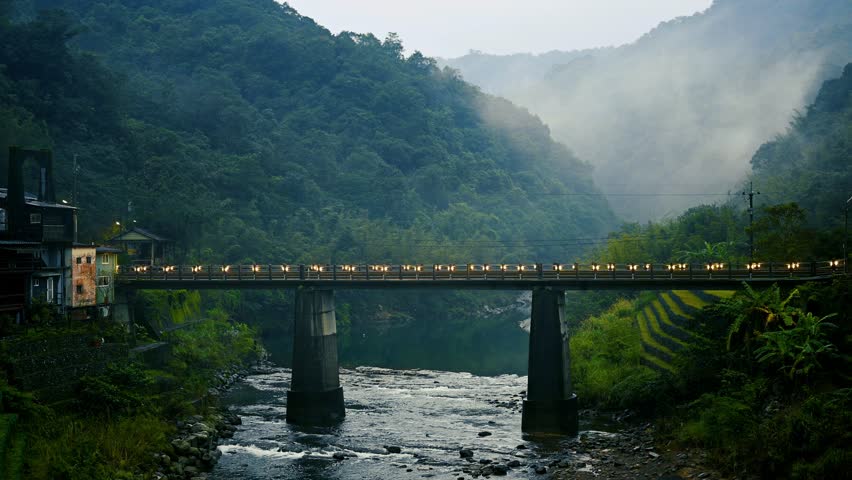 Trains pass over the bridge. The station next to a stream in a foggy valley. Sandiaoling Railway Station, New Taipei City, Taiwan. Royalty-Free Stock Footage #1098534695