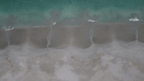 4k video of clear ocean water coming to the sandy shore in Australia. Video was taken by a drone.