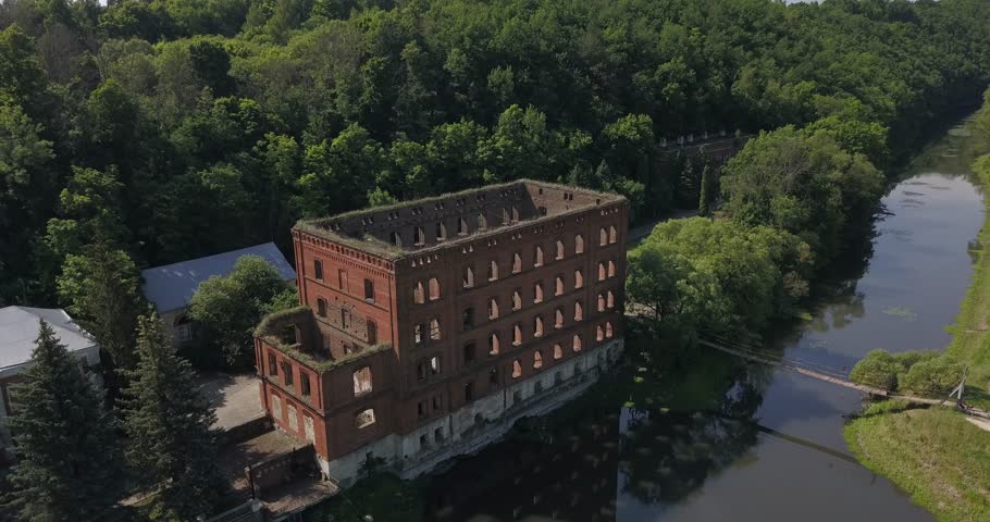 4K summer morning aerial video of mill building ruins by the river in central Russia