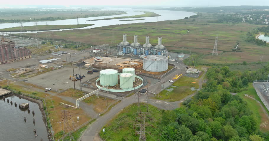 Located coast of bay on outskirts of city an old thermal power station which is not operating