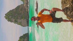 Active lifestyle travel people making video amazing coastline tropical beach Bali on background ocean with scenery rock cliff in sea 4K