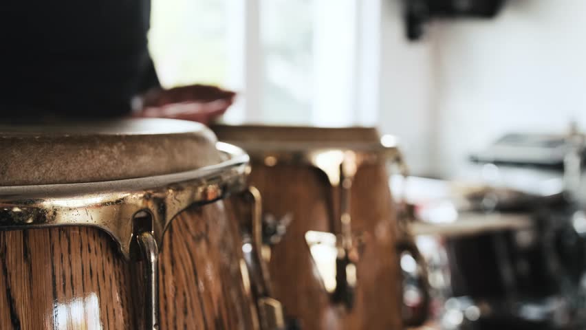 Man hands playing on kongo drums in recording studio. Guy with traditional ethnic african folk music instruments | Shutterstock HD Video #1098555555