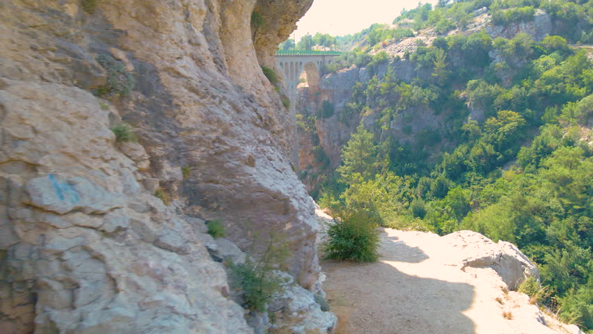 Historical Arches Bridge railway slow zoom-in 4k aerial drone between mountains and a vast green forest on a sunny day and bright sky. Vintage bridge with several arches. An old bridge in Turkey
