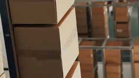 Vertical video: Warehouse filled with raw materials and racks to put cardboard boxes, preparing packages with merchandise and products for shipping. Empty storage room used for quality control, small