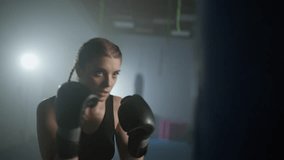 Woman power, female fighter beats a punching bag, trains his punches, training day in the boxing gym, the female strikes fast, cinematic lighting. - Powered by Shutterstock - Get 15% off with code: PIKWIZARD15