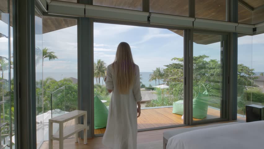 Woman walks to the balcony from luxury villa bedroom Royalty-Free Stock Footage #1098574267