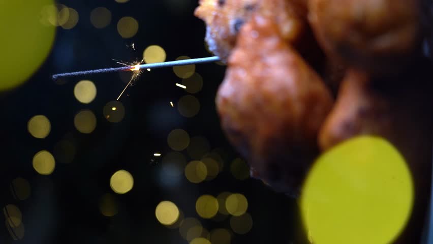 'Oliebollen', traditional Dutch pastry for New Year's Eve with sparkles. oil dumpling or fritter with sugar powder on top. Christmas tree lights bokeh on background. Typical food | Shutterstock HD Video #1098577775