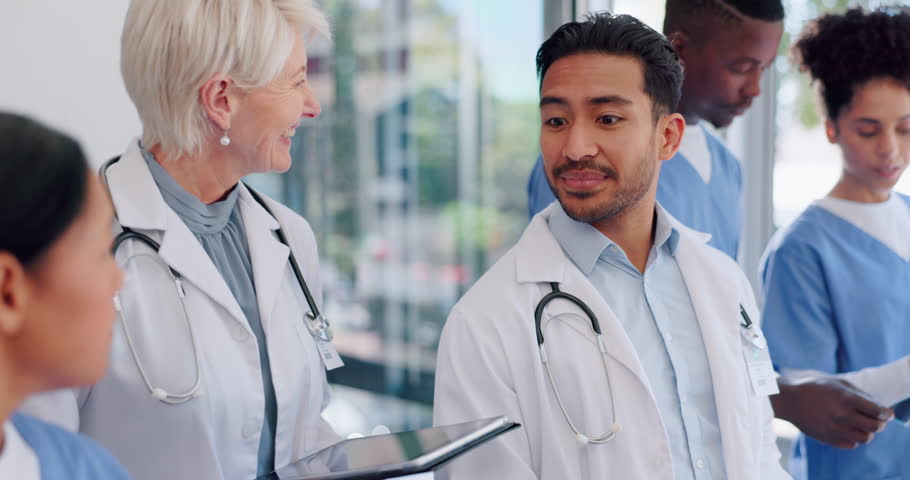 Doctors, talking and walking with tablet in hospital, conversation and chatting. Healthcare, medical technology and group of happy professional nurses, men and women in discussion in clinic lobby. Royalty-Free Stock Footage #1098580305