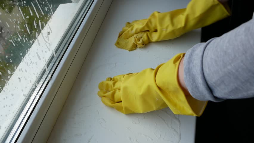 Woman's hand in yellow gloves washing windowsill. Window cleaning services | Shutterstock HD Video #1098584217