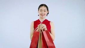 Beautiful asian woman wear traditional chinese dress carrying shopping bags in video 4K.