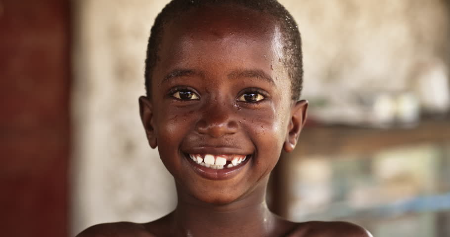 Portrait of a Smiling African Kid in a Rural Area Laughing and Looking at the Camera. Little Face Full Of Joy and Life After Having Fun Playing with Water and Getting Refreshed in Summer Hot Weather Royalty-Free Stock Footage #1098588433