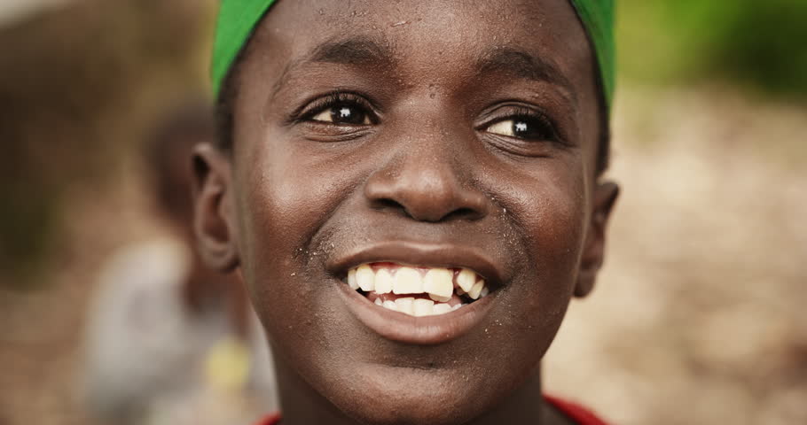 Close Up Portrait of an Expressive Authentic African Kid Smiling, Winking and Looking at the Camera Blurry Background. Happy Energetic Black Boy Full of Life Doing Funny Faces and Playing Around Royalty-Free Stock Footage #1098588435
