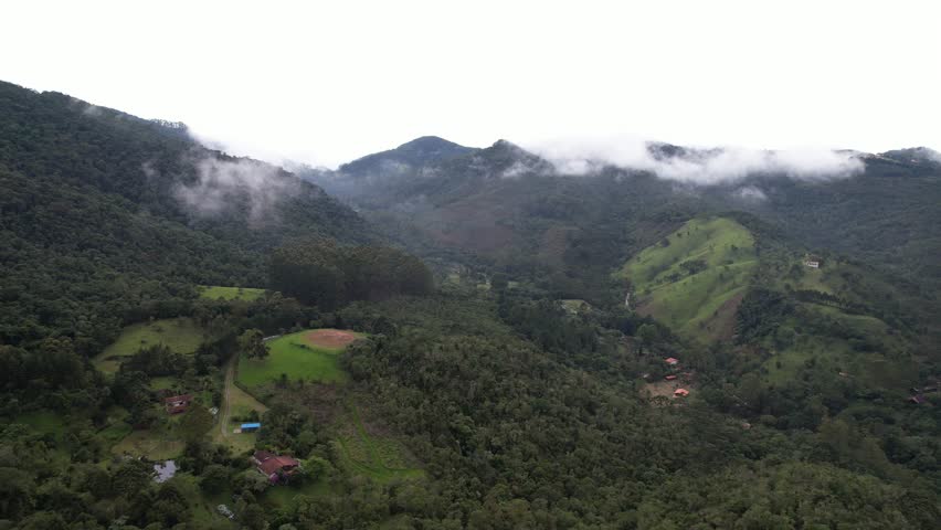 Low clouds covering part of the scenery. The clouds and fog approach the mountains covering part of the view and with blue sky on the horizon.