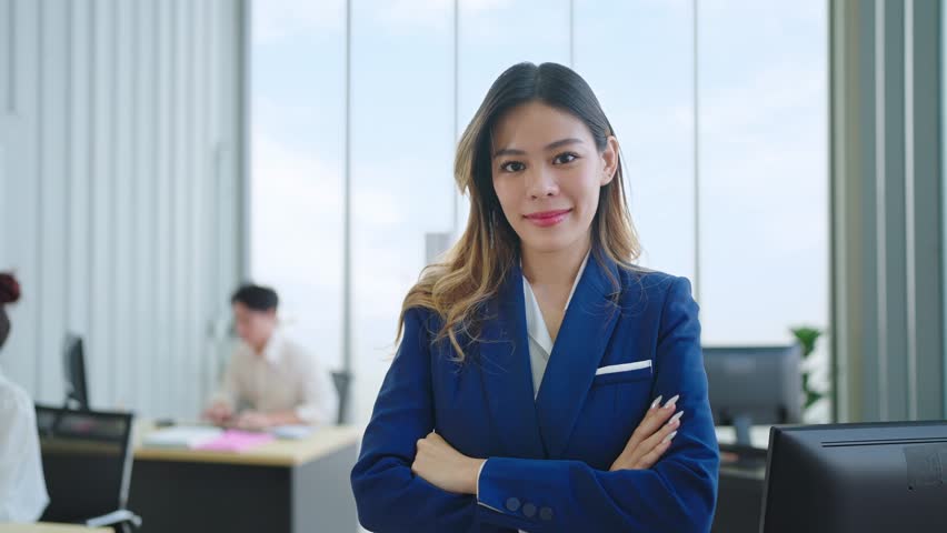 Young professional asian businesswoman with smilling face standing and crossing arms and looking at the camera | Shutterstock HD Video #1098592439