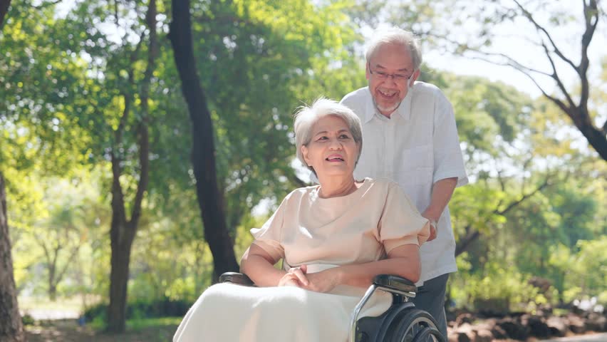 Happy Asian senior man pushing a wheelchair for wife outside in the park, Senior couple and retirement life concept Royalty-Free Stock Footage #1098594375