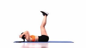 Young sportive girl lying on mat and training over white studio background. Lifting body, hands and legs. Modern sport, action, motion, youth concept. Fitness, hobby, healthy lifestyle