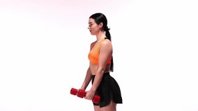 Young sportive girl training with dumbbells over white studio background. Hands training, dynamic lifting weights. Modern sport, action, motion, youth concept. Fitness, hobby, healthy lifestyle