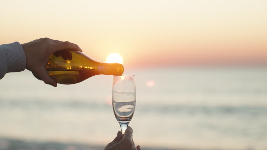 The girl Pours Champagne against the background of the Rising sun and the sea. close-up, Slow motion | Shutterstock HD Video #1098602239