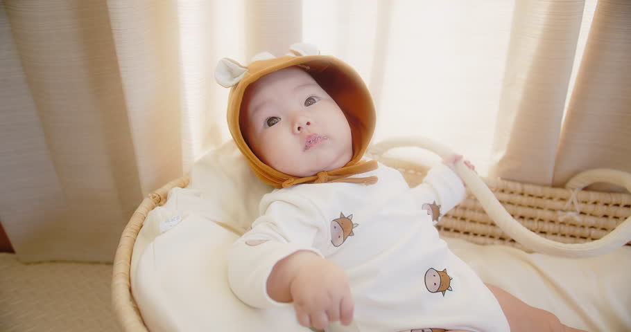 portrait happy family little cute adorable Asian baby wearing cow costume lying in basket relaxing at home