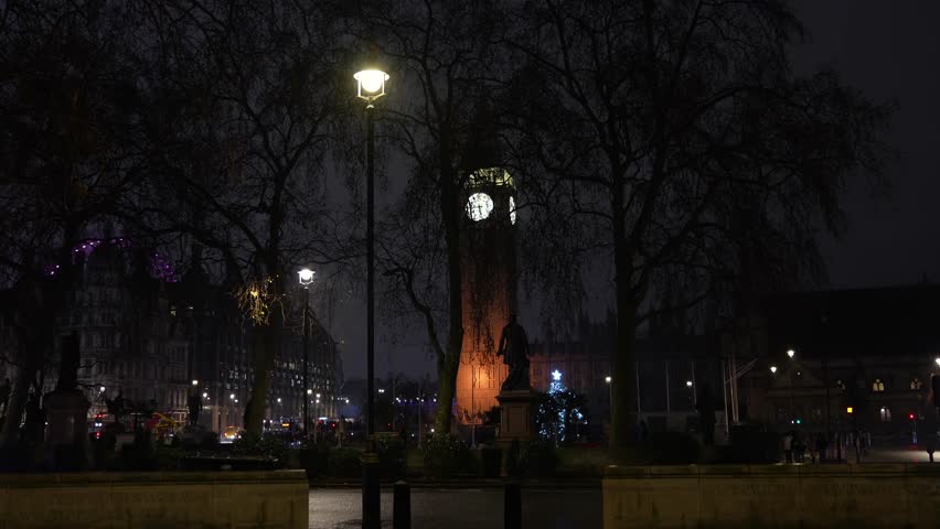 London in a rainy night. 4K video with Big Ben clock tower landmark filmed in the rain during a winter evening in London. Travel to England.