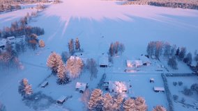 Scenic fly forward over small Swedish village, cold sunny winter day, sunset colored snow, forest, frozen lake - typical landscape of Northern Sweden - Powered by Shutterstock - Get 15% off with code: PIKWIZARD15