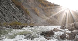 Beautiful mountain river with rapid current, bright shining sun, and mountain folds in Yaremche City, Ukraine, known as Yaremche folds - biggest outcrop of Stryi formation in Europe. Video with sound