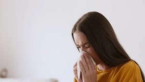 Infection disease. Close up portrait of young pretty woman coughing at home and blowing her nose, suffering from seasonal cold and flu, slow motion, empty space - Powered by Shutterstock - Get 15% off with code: PIKWIZARD15