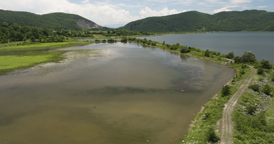 Grassy causeways with crude roads in Tkibuli lake reservoir, Georgia.