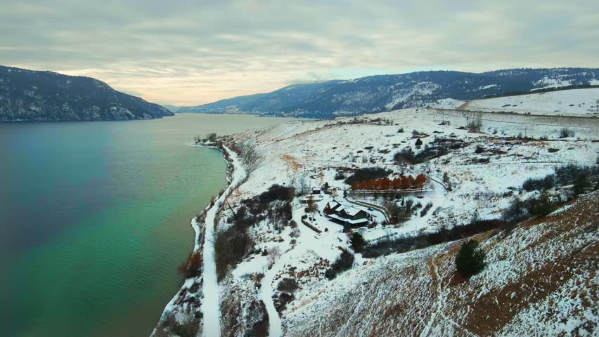 Aerial Perspective of Wood Lake in Kelowna: A View from Above of the Turquoise Water and Snow-Covered Red Cliffs along the Shore