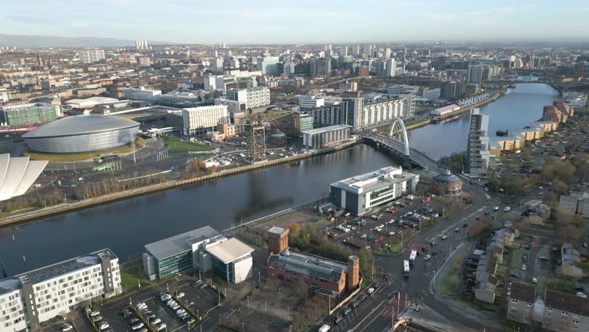 Glasgow Skyline with famous Glasgow landmarks, The OVO Hydro, SEC Armadillo and Finnieston Crane. Wide Aerial Backward.