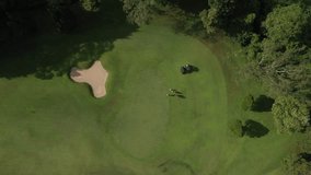 Aerial view of golf players at green field. High quality 4k footage
