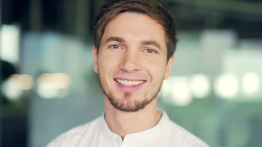Close-up portrait of young caucasian man looking at camera smiling. Head shot Handsome businessman standing in office. Successful happy male employee entrepreneur posing for recording video indoor | Shutterstock HD Video #1098620729