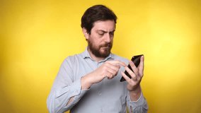 Video about sad man looks shocked at the phone on a yellow background