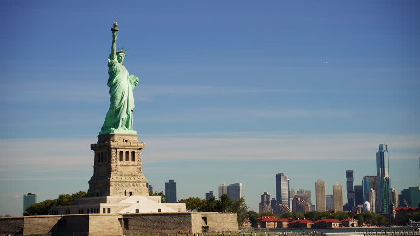 A wide shot of the Statue of Liberty located at Liberty Island in New York Harbor against New York City skyline during daytime Royalty-Free Stock Footage #1098627565