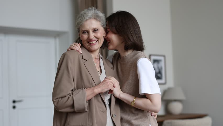 adult daughter and her gray-haired mother embracing look at the camera with smiles on their faces Royalty-Free Stock Footage #1098632591