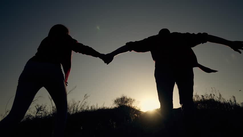Teamwork. Helping hand. Silhouette of people running up mountain reaching goal. People run up to success. Teamwork achieves goal of success. Help in work, hold hand of partner. Royalty-Free Stock Footage #1098632727