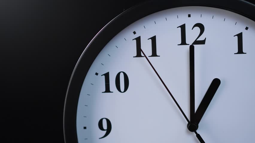 Analog wall clock on a black background in a closed socket | Shutterstock HD Video #1098637219