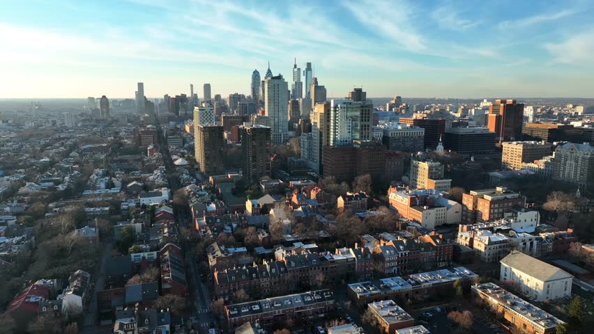 Residential district with urban city skyline during golden hour. Philadelphia Pennsylvania USA establishing shot during winter. Royalty-Free Stock Footage #1098638513