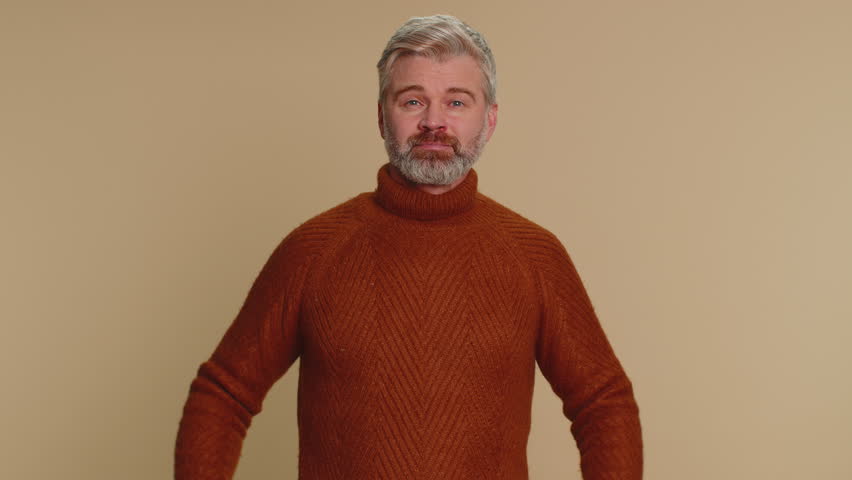 Please, God help, forgive me. Middle-aged old man praying, looking upward and making wish, asking with hopeful imploring expression, begging apology. Senior mature guy on beige studio background