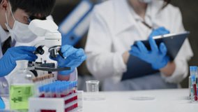 Team scientists is working on chemistry and biology tests and using microscope in laboratory for develop and analysis virus vaccine and pharmacy medicine. - Powered by Shutterstock - Get 15% off with code: PIKWIZARD15