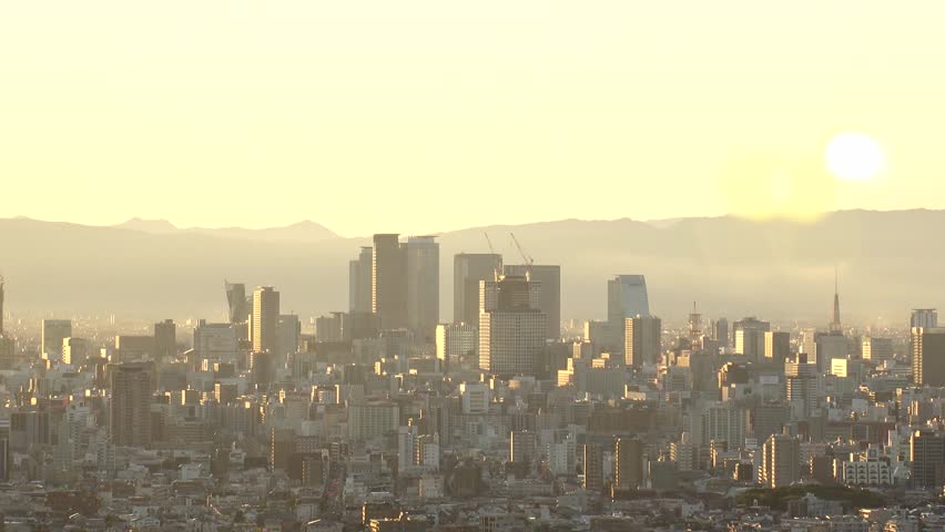 NAGOYA, JAPAN - OCT 2022 : Aerial high angle view of NAGOYA CITY in sunset. View of buildings and street traffic around Nagoya station and Sakae area (central downtown). Time lapse shot, dusk to night