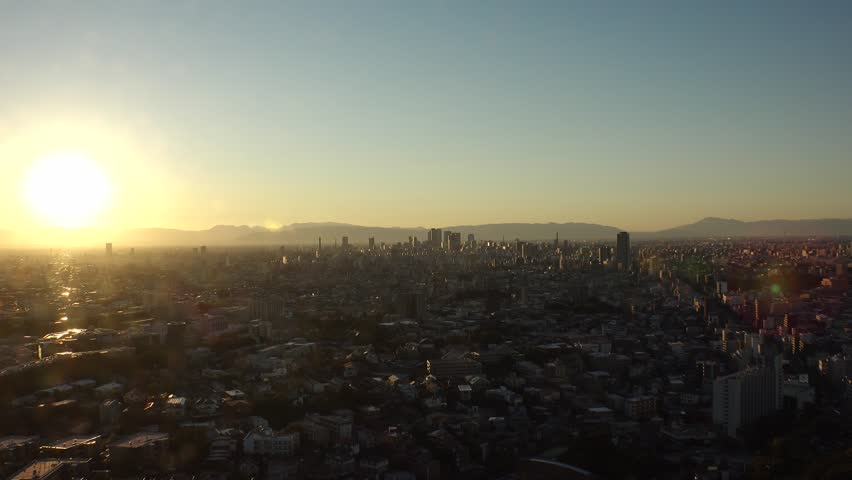 NAGOYA, JAPAN - OCTOBER 2022 : NAGOYA CITY in sunset. Aerial high angle view of buildings and street traffic around Nagoya station and Sakae area (central downtown). Time lapse shot, dusk to night.