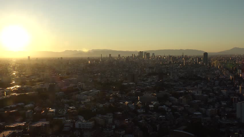 NAGOYA, JAPAN - OCTOBER 2022 : NAGOYA CITY in sunset. Aerial high angle view of buildings and street traffic around Nagoya station and Sakae area (central downtown). Time lapse shot, dusk to night.