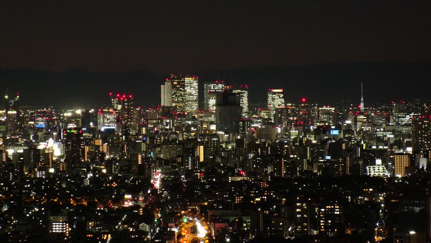 NAGOYA, JAPAN- OCT 2022 : NAGOYA CITY at night. Aerial high angle view of buildings and street traffic around Nagoya station and Sakae area (central downtown). Time lapse shot. Travel concept video.