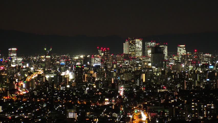 NAGOYA, JAPAN- OCT 2022 : NAGOYA CITY at night. Aerial high angle view of buildings and street traffic around Nagoya station and Sakae area (central downtown). Time lapse shot. Travel concept video.