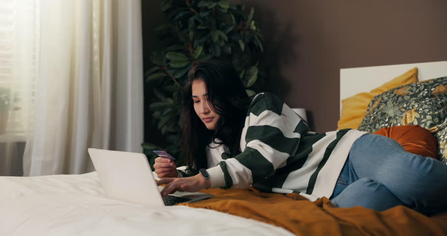 Accept the transaction on the bank's website. A woman pays with a credit card for online purchases. Confirmation of payment makes the girl happy with the products she ordered. | Shutterstock HD Video #1098644165